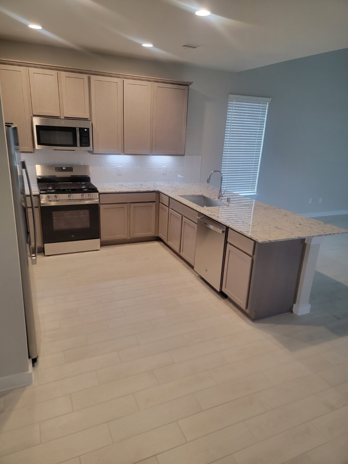 3130 Boulder Ridge Drive Rosenberg, TX 77471 - Photo 10 of 32 a kitchen with stainless steel appliances a stove a microwave a sink and cabinets