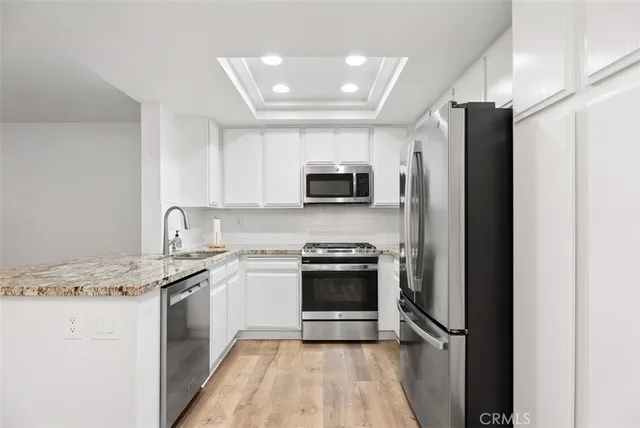 a kitchen with stainless steel appliances granite countertop a stove a refrigerator and a sink