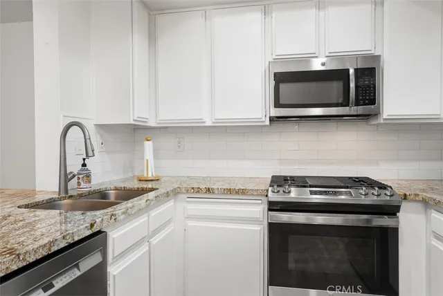 a kitchen with granite countertop a stove and a microwave