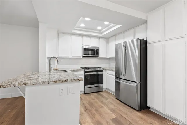 a kitchen with granite countertop a refrigerator stove and microwave