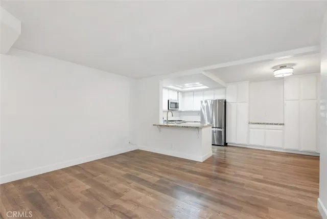 a view of a kitchen with wooden floor and a sink