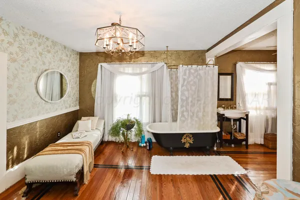 a living room with furniture a lamp and a potted plant