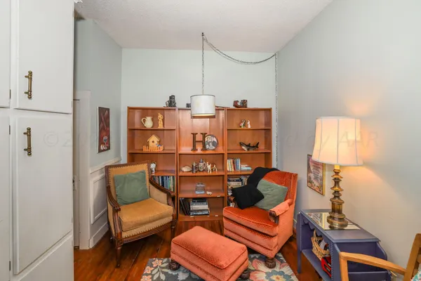 a view of a livingroom with wooden floor and furniture