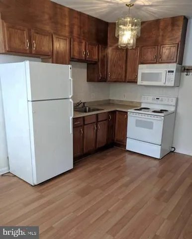 a kitchen with stainless steel appliances granite countertop a refrigerator a stove top oven a sink and dishwasher