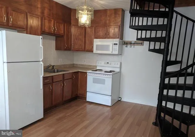 a kitchen with a white stove refrigerator and cabinets