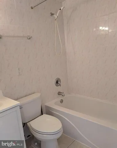 a white toilet and tub sitting next to a bathroom sink