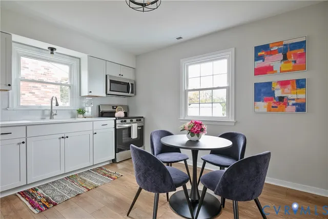 a kitchen with stainless steel appliances a dining table and chairs