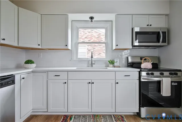 a kitchen with white cabinets and white appliances