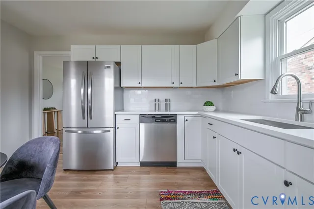 a kitchen with a refrigerator sink and cabinets