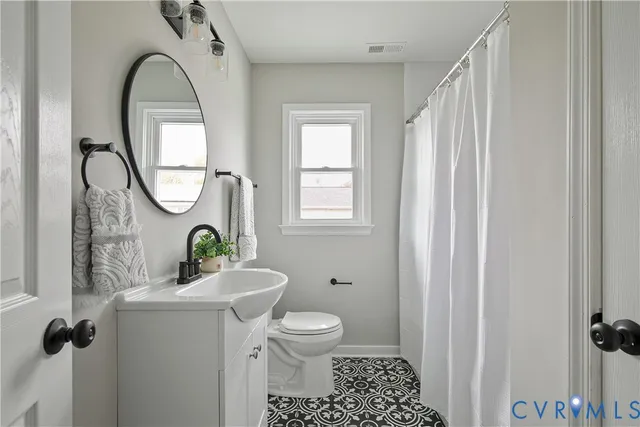 a bathroom with a toilet a sink and a mirror