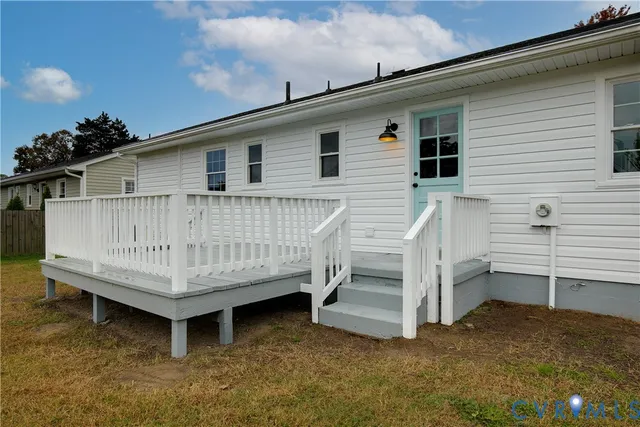 a view of a house with a wooden deck and a yard