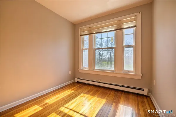a view of a room with wooden floor and windows