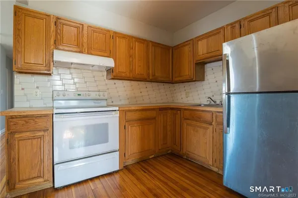 a kitchen with stainless steel appliances granite countertop a refrigerator sink and stove