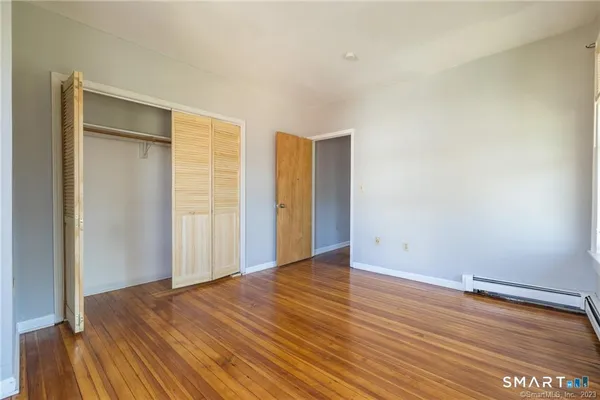 a view of an empty room with wooden floor