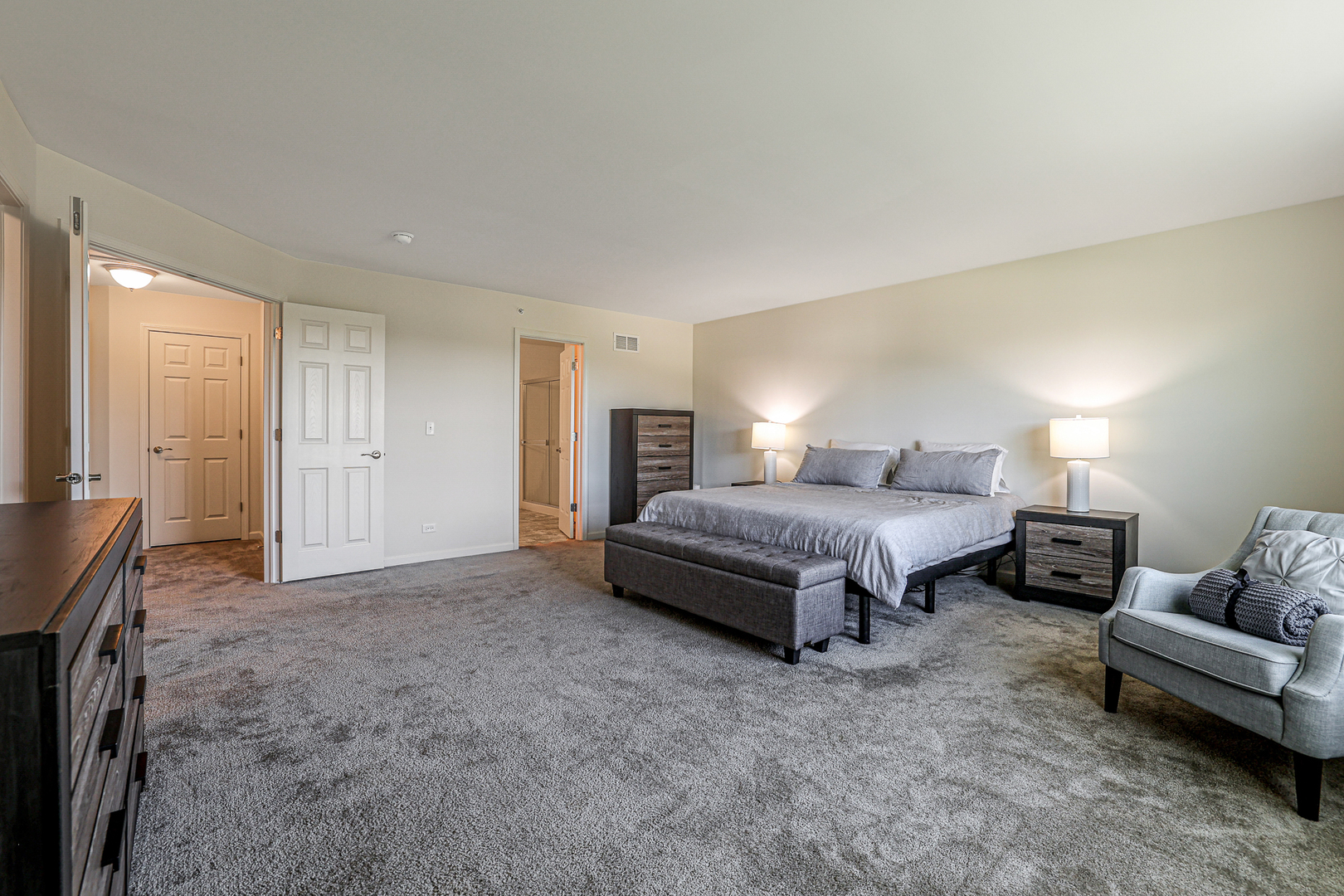 5835 Fairview Lane Hoffman Estates, IL 60192 - Photo 21 of 33 a spacious bedroom with a bed a couch and a dresser with wooden floor