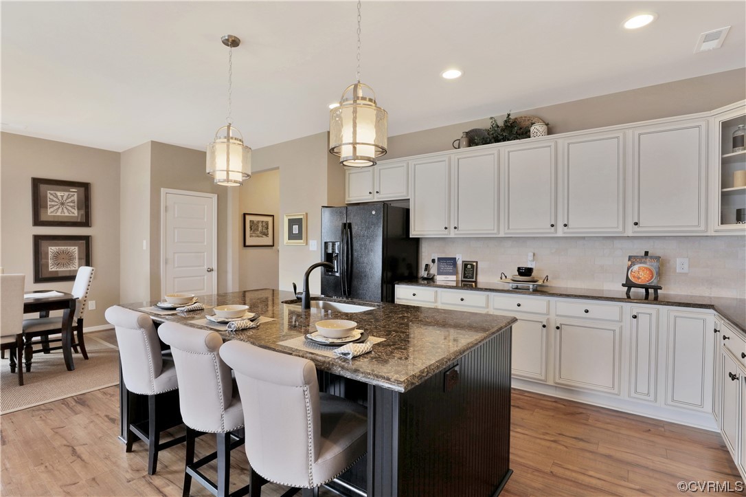 a kitchen that has a lot of cabinets in it and wooden floors