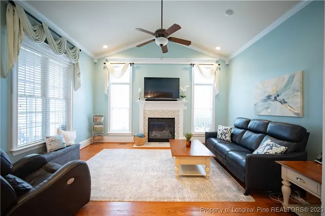 a living room with furniture a fireplace and a flat screen tv