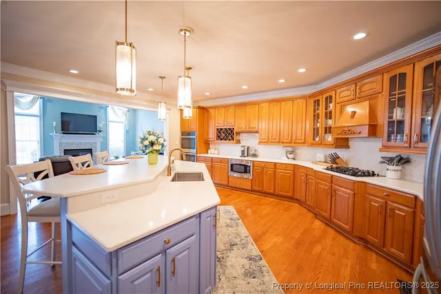 a large kitchen with kitchen island a large counter top space a sink stainless steel appliances and cabinets