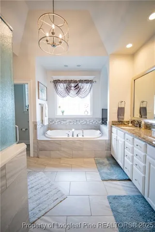 a spacious bathroom with a tub sink and mirror