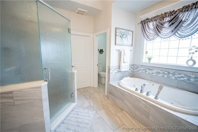 a bathroom with a bathtub a window and a shower