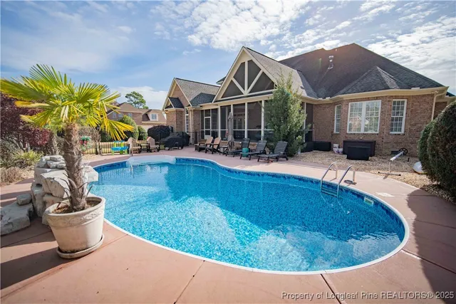 a view of a house with swimming pool and sitting area