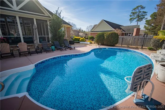 a view of a house with swimming pool and sitting area