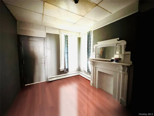 a view of a livingroom with wooden floor and a fireplace