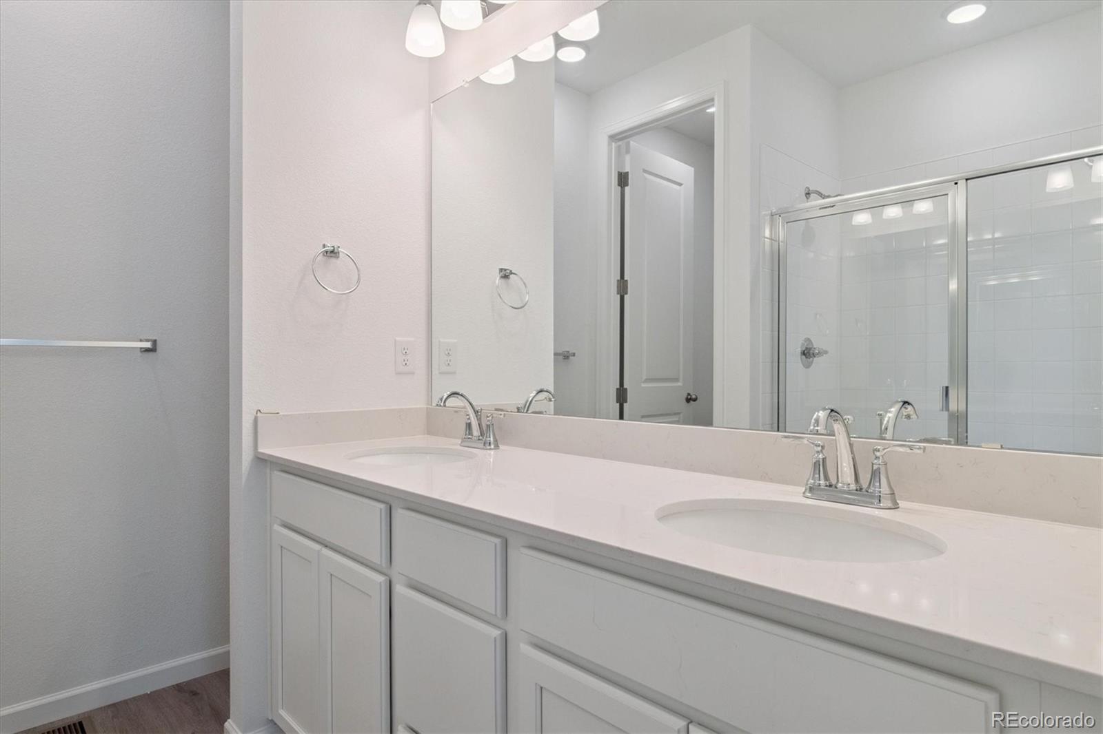 8317 Eagle River Street Littleton, CO 80125 - Photo 14 of 18 a bathroom with a sink double vanity and a mirror