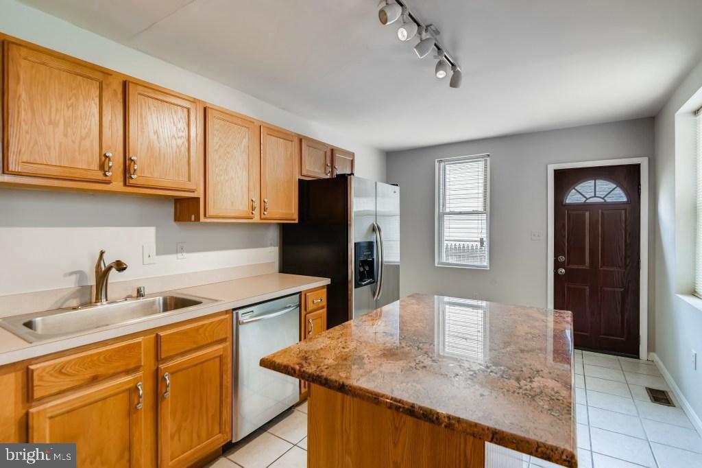 a kitchen with stainless steel appliances granite countertop a sink a microwave refrigerator and cabinets