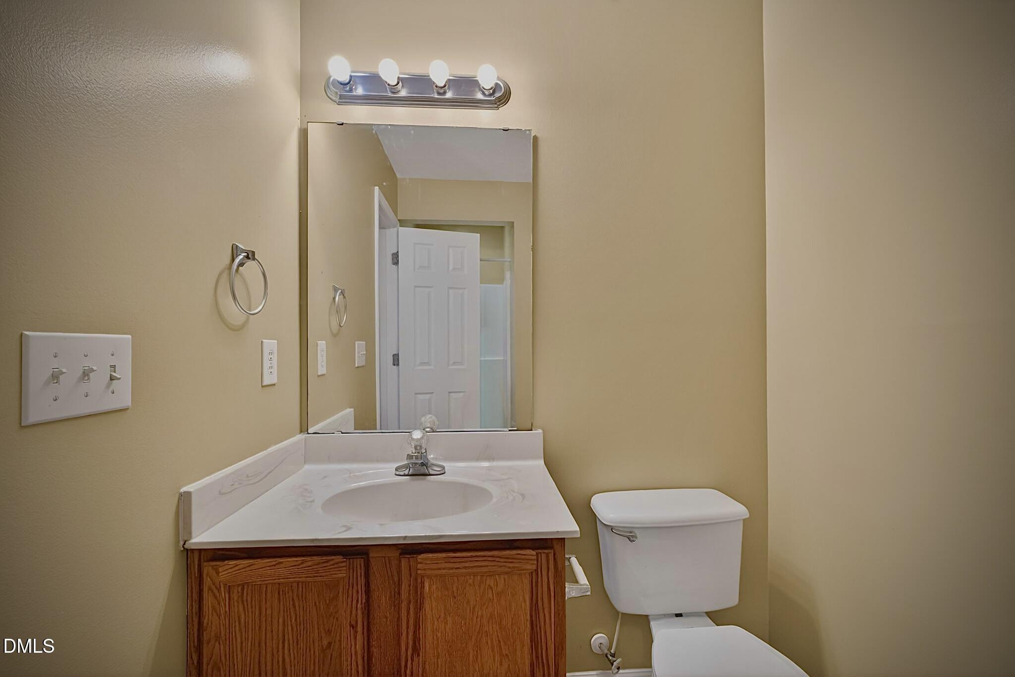 5415 Gunnette Drive Raleigh, NC 27610 - Photo 13 of 37 a bathroom with a sink a toilet and mirror