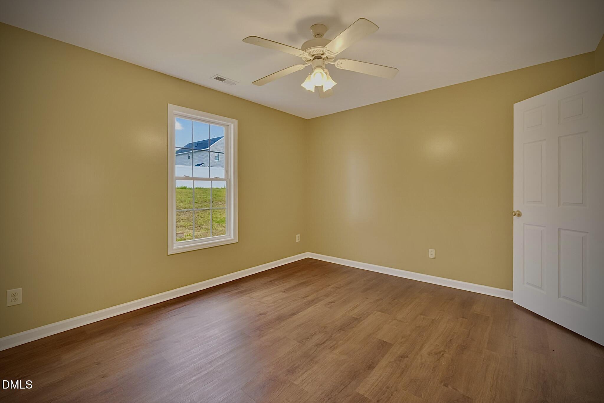 5415 Gunnette Drive Raleigh, NC 27610 - Photo 9 of 37 an empty room with a window and a ceiling fan