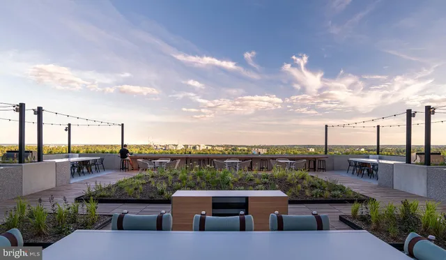 a view of a patio with table and chairs potted plants and floor to ceiling window and potted plants