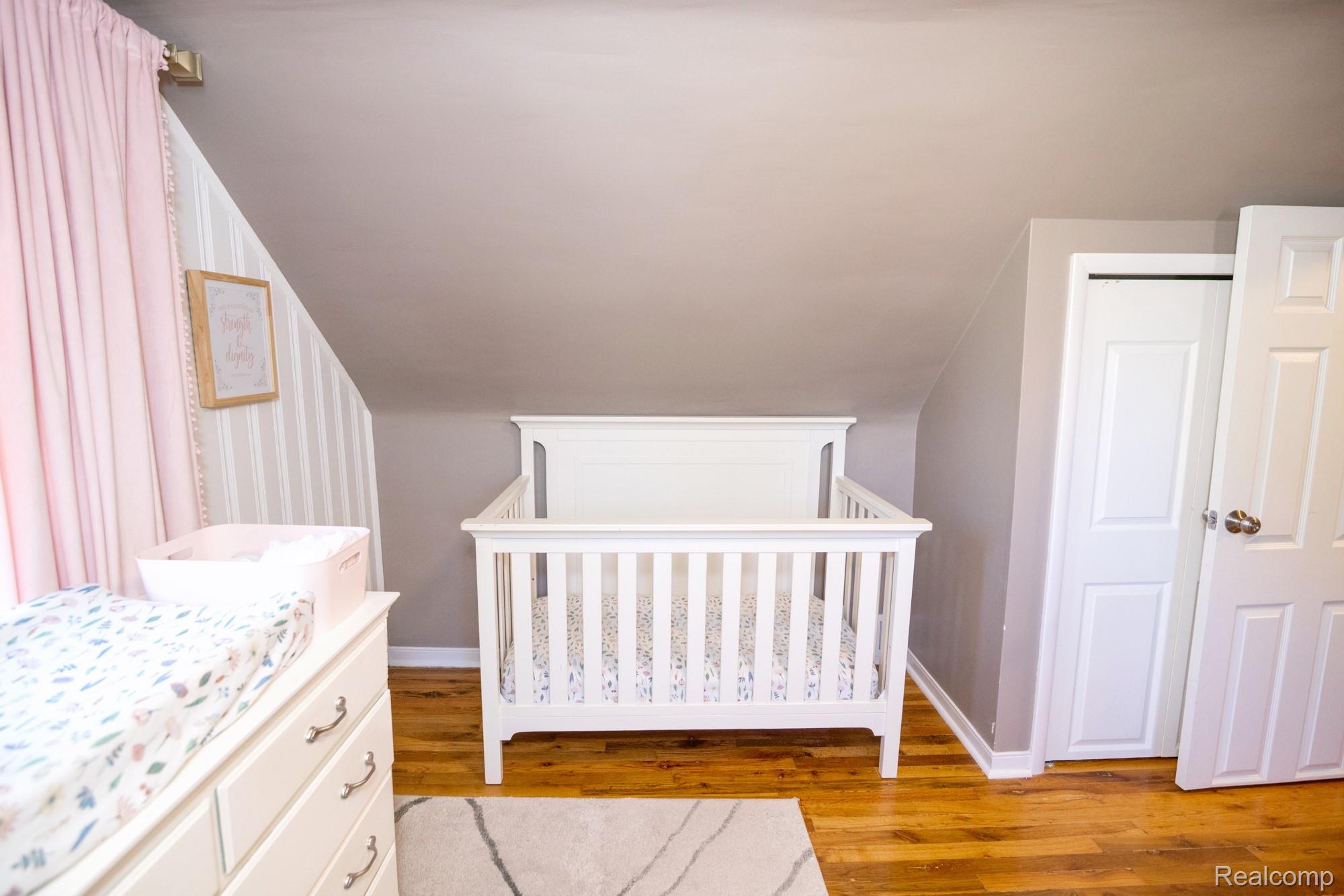 3757 Cone Avenue Rochester, MI 48309 - Photo 25 of 45 Bedroom featuring hardwood flooring, sloped ceiling, and a built-in closet with a bi-fold door and a swing door