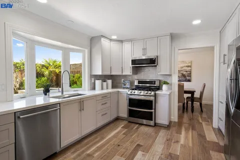 a kitchen with stainless steel appliances a stove sink microwave and cabinets