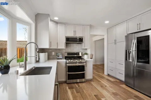 a kitchen with stainless steel appliances a stove a sink a microwave and cabinets