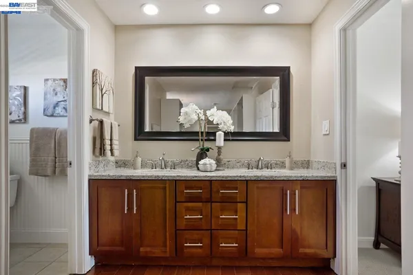 a bathroom with a granite countertop sink a toilet and mirror