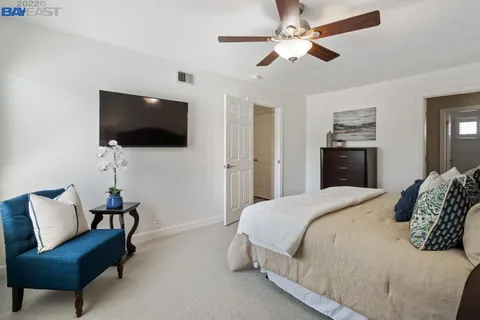 a bedroom with a bed a flat screen tv and a couch