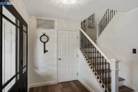 a view of a hallway with wooden floor and entryway