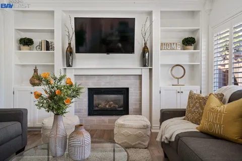 a living room with furniture a flat screen tv and a fireplace