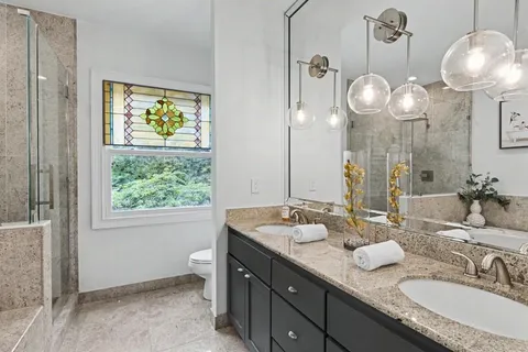 a bathroom with a granite countertop sink and a large mirror