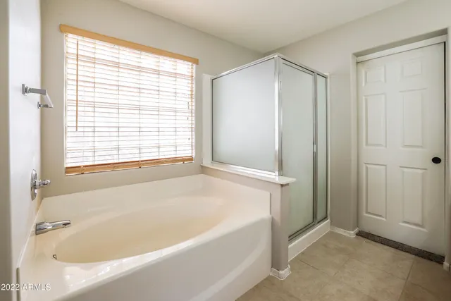 a white bath tub sitting in a bathroom next to a window