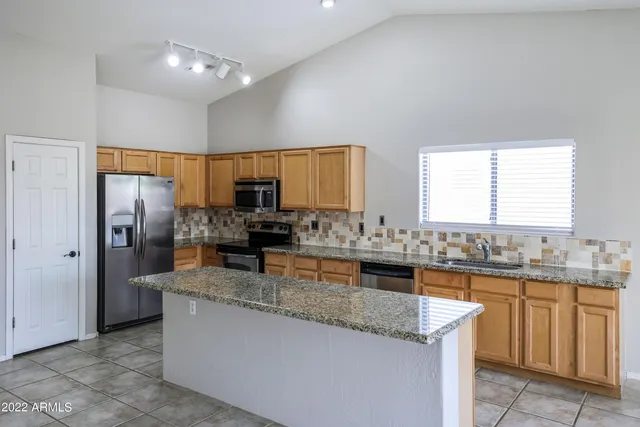 a kitchen with stainless steel appliances granite countertop a sink a stove counter space and cabinets