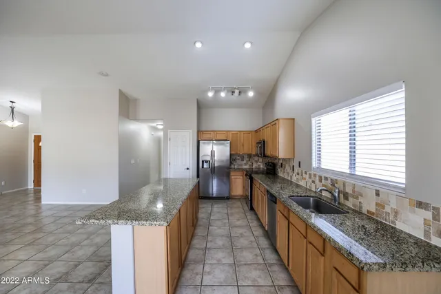 a large kitchen with kitchen island granite countertop a large counter top and sink