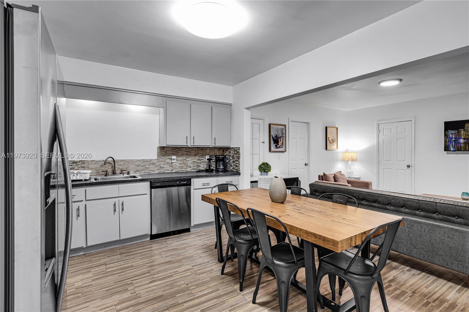 977 Southwest 10th Street, Unit 927 Miami, FL 33130 - Photo 5 of 18 a kitchen with granite countertop kitchen island wooden floor and stainless steel appliances