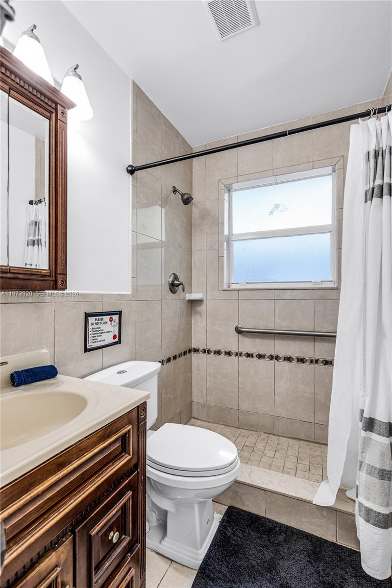 977 Southwest 10th Street, Unit 927 Miami, FL 33130 - Photo 8 of 18 a bathroom with a sink a toilet and shower