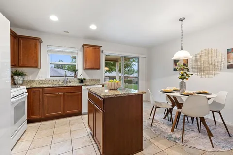 a kitchen with stainless steel appliances granite countertop a stove a sink and a microwave