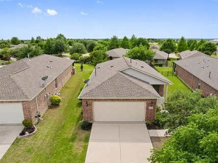 an aerial view of a house with swimming pool and large trees