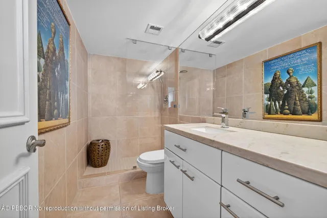 a bathroom with a granite countertop sink mirror vanity and toilet