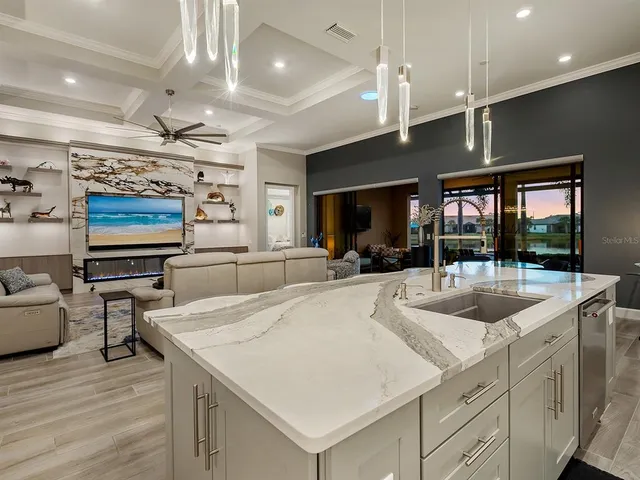 a kitchen with kitchen island granite countertop a table chairs sink and cabinets