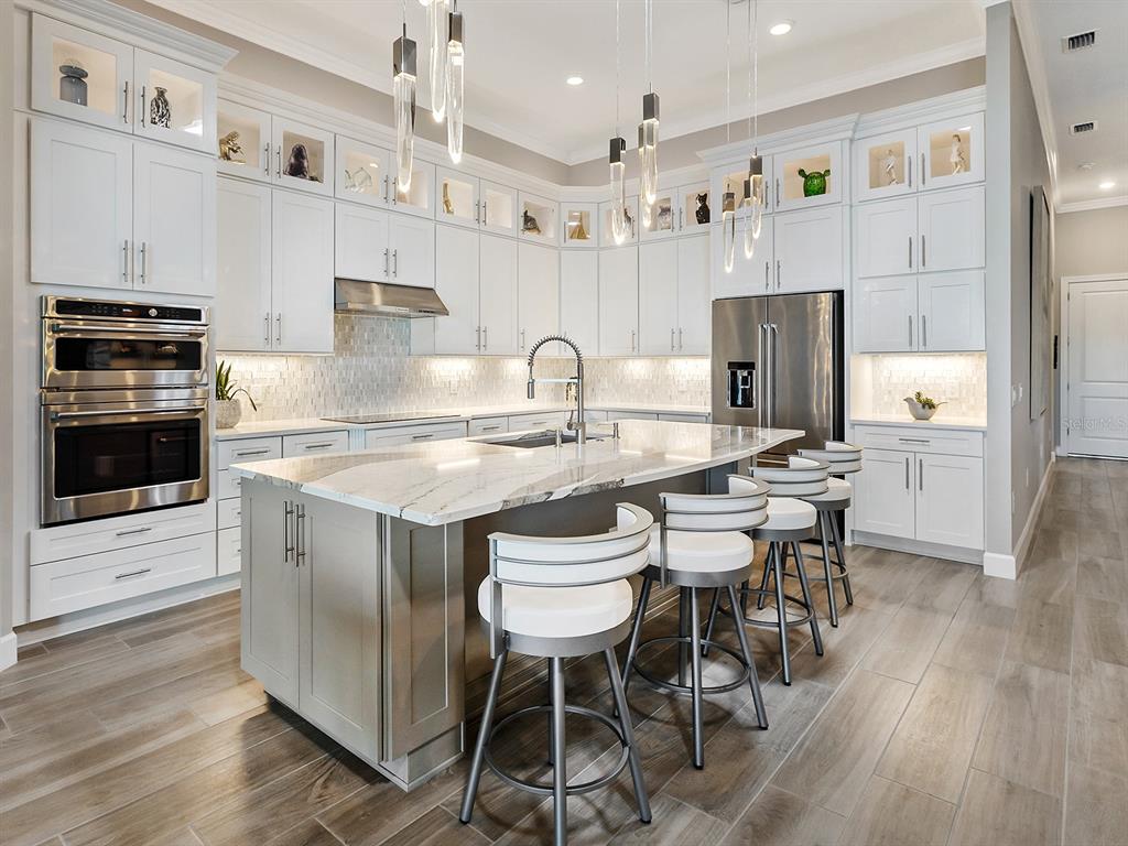 17807 Eastbrook Terrace Lakewood Ranch, FL 34202 - Photo 28 of 92 a kitchen with a dining table chairs and white appliances